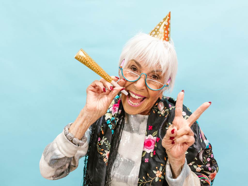 une dame âgée souriante qui fume un joint